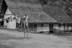 Traditional Village Scene with Man on Stilts