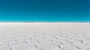 Vast salar with geometric patterns under a clear blue sky in Bolivia's Uyuni.