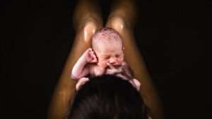 A woman holding a baby up in the air