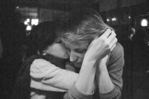 Two people embracing in a dimly lit setting