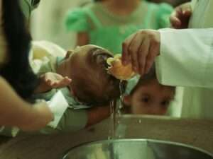 Baby being baptized with water poured on head