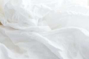 a close up of a bed with white sheets