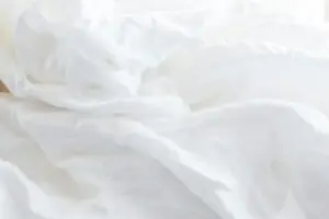 a close up of a bed with white sheets