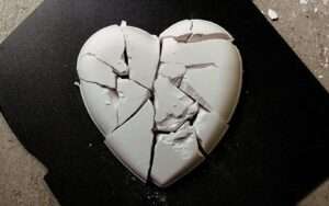A broken heart shaped cookie sitting on top of a table