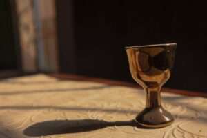 a small glass sitting on top of a bed