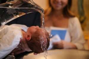 A baby being washed in a kitchen sink
