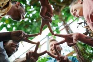 Group of diverse friends forming a star shape with their fingers, symbolizing unity and friendship.