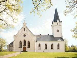 Beautiful Lutheran church in Jaunpiebalga, Latvia, surrounded by spring foliage.