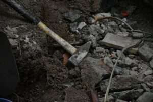a hammer laying on top of a pile of rubble
